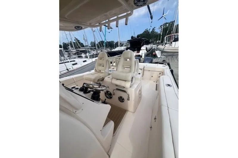  Yacht Photos Pics 2023 Grady-White Canyon 306 boat interior with helm and seating at marina.