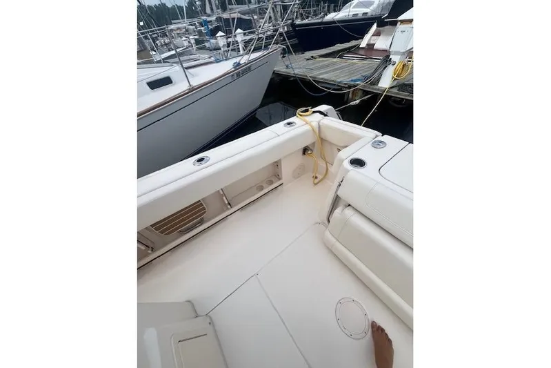  Yacht Photos Pics 2023 Grady-White Canyon 306 boat interior at marina, featuring seating and docked vessels.