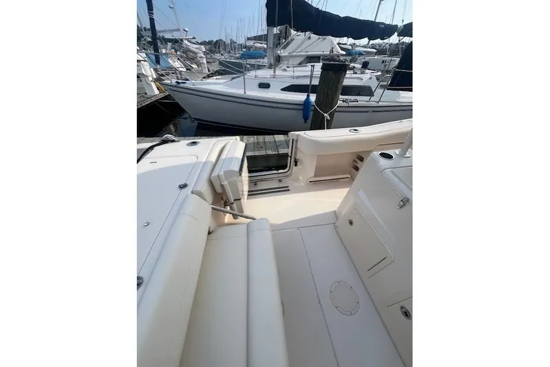  Yacht Photos Pics 2023 Grady-White Canyon 306 boat interior at marina, showcasing seating and deck layout.