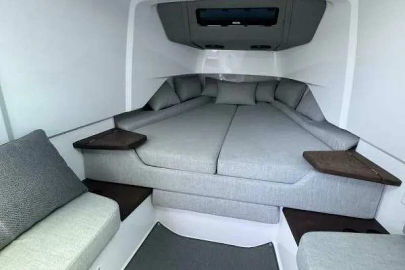 Milan Yacht Photos Pics 2024 Axopar 37 Sun Top cabin interior with gray cushions and wooden accents.