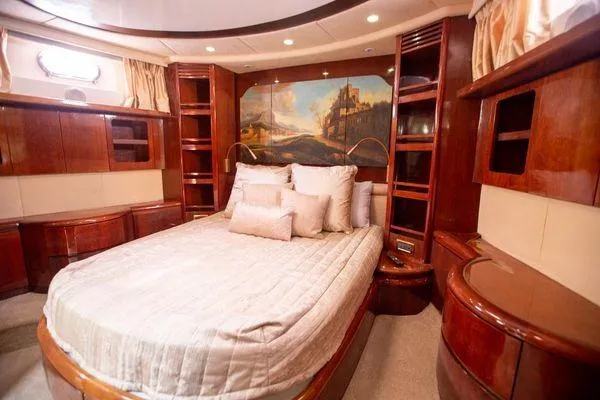 Ghost Rider Yacht Photos Pics Luxurious bedroom interior of 2003 Azimut 74 Solar yacht with elegant wood finishes.