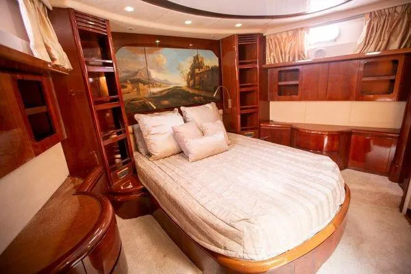 Ghost Rider Yacht Photos Pics Luxurious bedroom interior of 2003 Azimut 74 Solar yacht with elegant wood finishes.