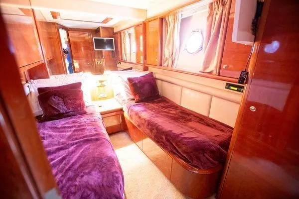 Ghost Rider Yacht Photos Pics Luxurious cabin interior of 2003 Azimut 74 Solar yacht with twin beds and rich wood finish.