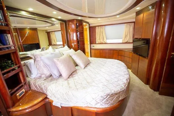 Ghost Rider Yacht Photos Pics Luxurious bedroom interior of 2003 Azimut 74 Solar yacht with elegant wood finishes.