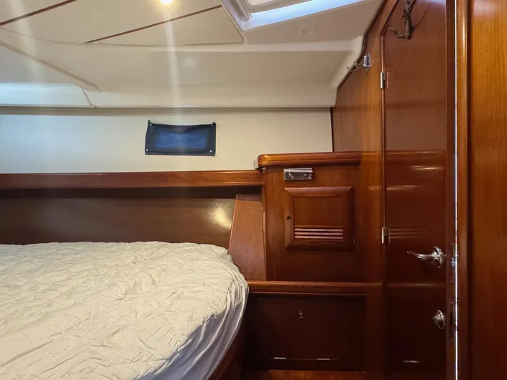 Sanctuary Yacht Photos Pics Interior cabin of 2005 Beneteau Oceanis Clipper 473 with wooden finish and bed.