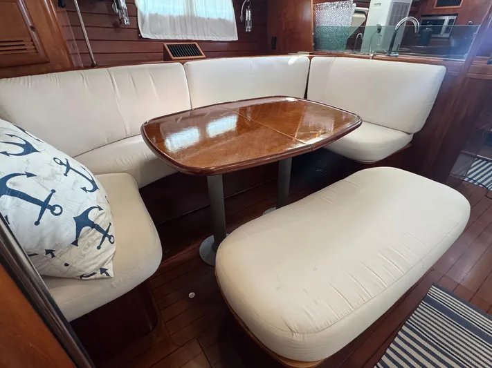 Sanctuary Yacht Photos Pics Interior of 2005 Beneteau Oceanis Clipper 473 with cozy seating and wooden table.
