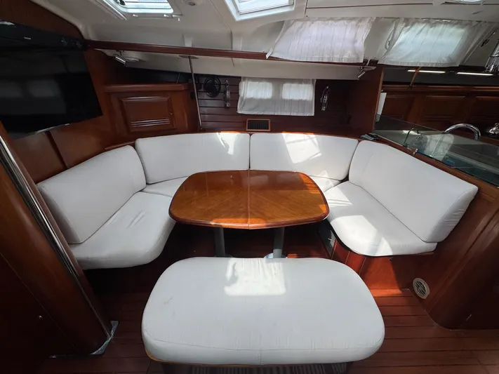 Sanctuary Yacht Photos Pics Interior of 2005 Beneteau Oceanis Clipper 473 yacht with cozy seating and wooden table.