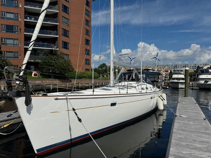 Sanctuary Yacht Photos Pics 2005 Beneteau Oceanis Clipper 473 yacht docked at marina, with modern buildings in background.