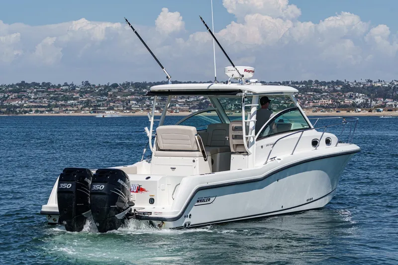 Slingshot Yacht Photos Pics 2018 Boston Whaler 315 Conquest boat cruising on a sunny day near the coastline.