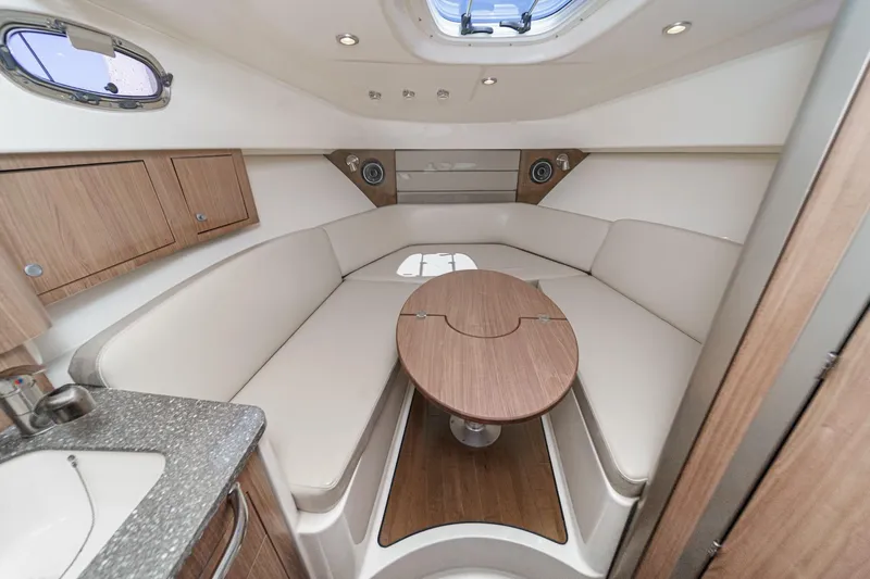 Slingshot Yacht Photos Pics Luxurious interior of 2018 Boston Whaler 315 Conquest with elegant seating and wooden table.