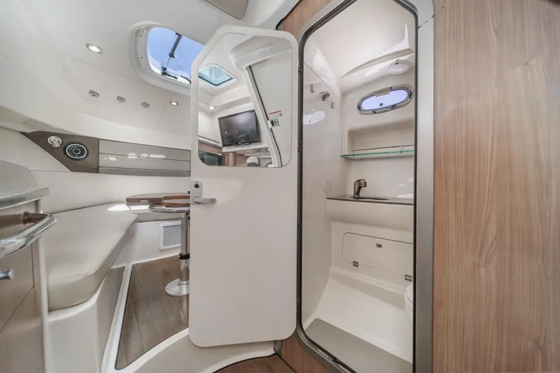 Slingshot Yacht Photos Pics 2018 Boston Whaler 315 Conquest cabin interior with seating, table, and bathroom.