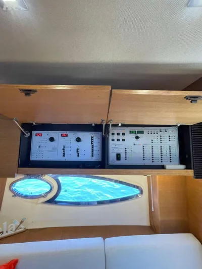  Yacht Photos Pics Electrical control panel inside 2013 Azimut Atlantis 54 yacht, with a view of the sea through a porthole.
