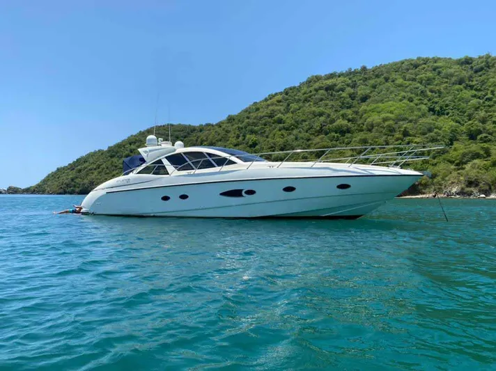  Yacht Photos Pics 2013 Azimut Atlantis 54 yacht anchored in clear blue waters near a lush green island.