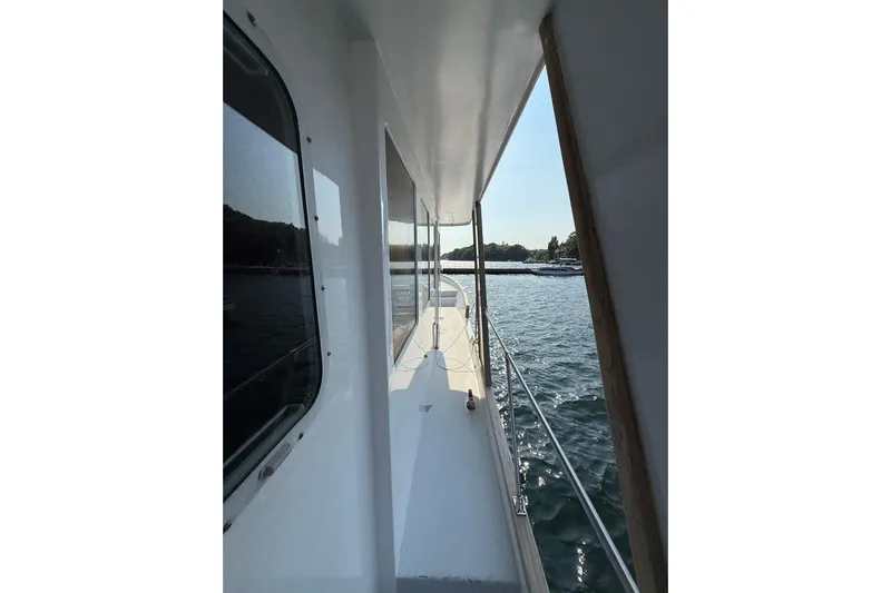 Yacht Photos Pics Side view of a 1994 Custom 60 Trawler on calm water, showcasing its sleek design.