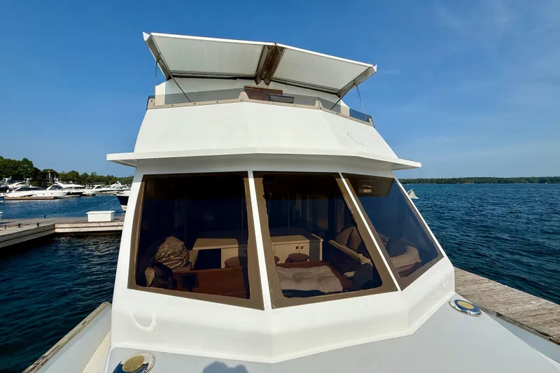  Yacht Photos Pics Custom 60 Trawler 1994 docked by the water, showcasing its cabin and windows.