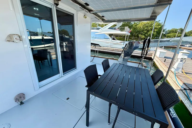  Yacht Photos Pics Outdoor dining area on a 1994 Custom 60 Trawler, featuring a sleek black table and chairs.