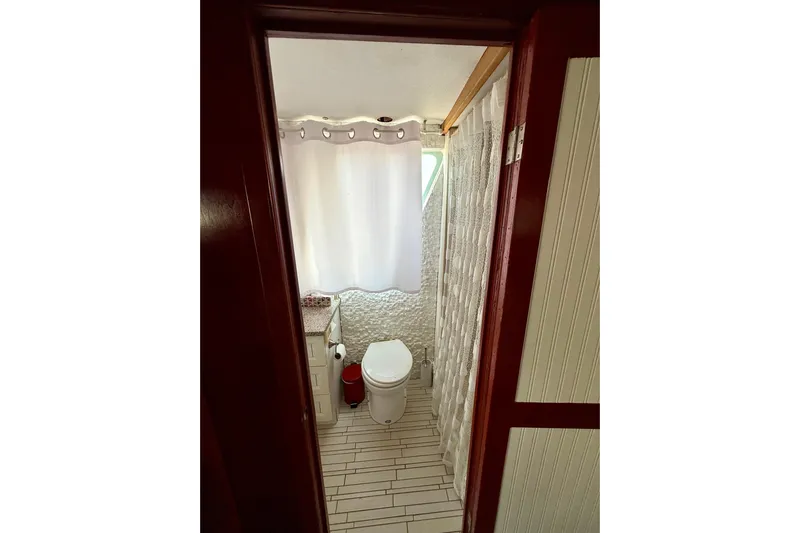  Yacht Photos Pics Bathroom interior of 1994 Custom 60 Trawler with white tiles and shower curtain.