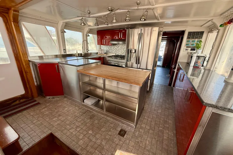  Yacht Photos Pics Luxurious 1994 Custom 60 Trawler kitchen with modern appliances and sleek red cabinetry.