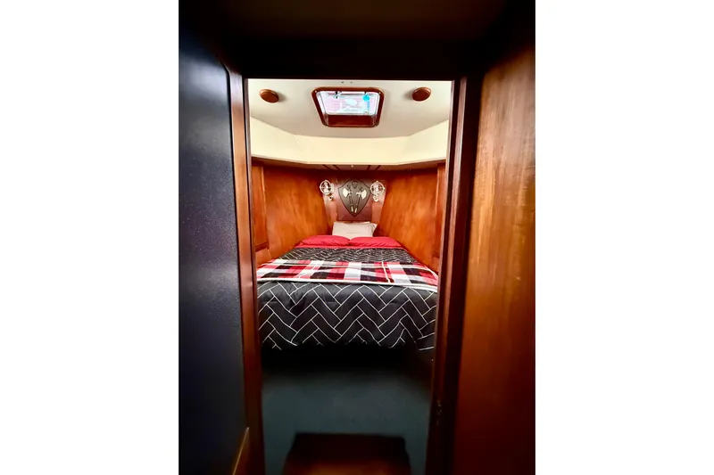  Yacht Photos Pics Cozy cabin interior of 1994 Custom 60 Trawler with wood paneling and patterned bedding.