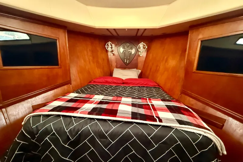  Yacht Photos Pics Cozy cabin interior of a 1994 Custom 60 Trawler with wood paneling and plaid bedding.