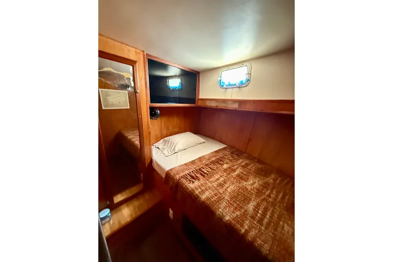  Yacht Photos Pics Cozy cabin interior of 1994 Custom 60 Trawler with wooden paneling and single bed.
