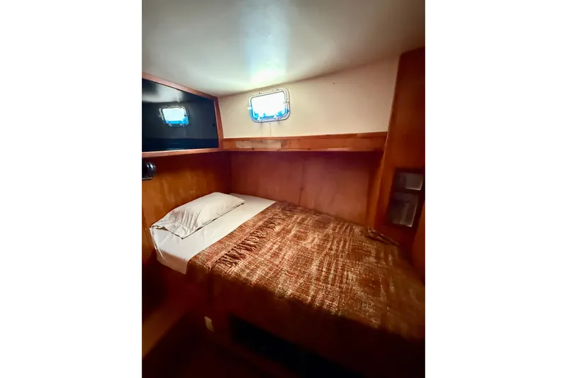  Yacht Photos Pics Cozy cabin interior of 1994 Custom 60 Trawler with single bed and porthole window.