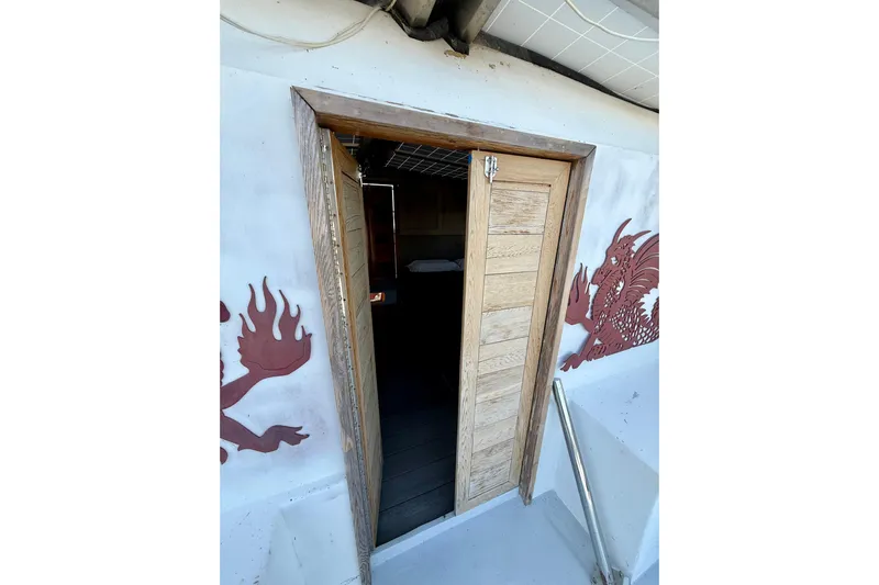  Yacht Photos Pics Wooden door on 1994 Custom 60 Trawler with dragon artwork on white exterior.