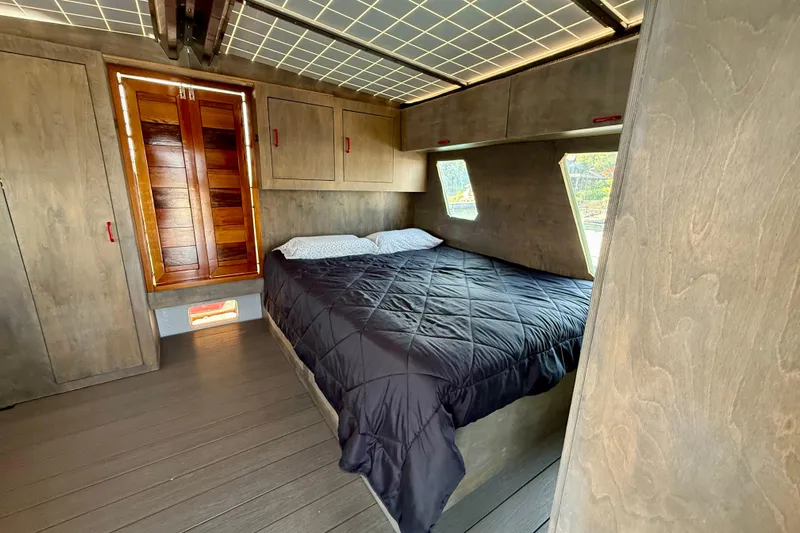  Yacht Photos Pics Cozy bedroom interior of a 1994 Custom 60 Trawler with wood paneling and a double bed.