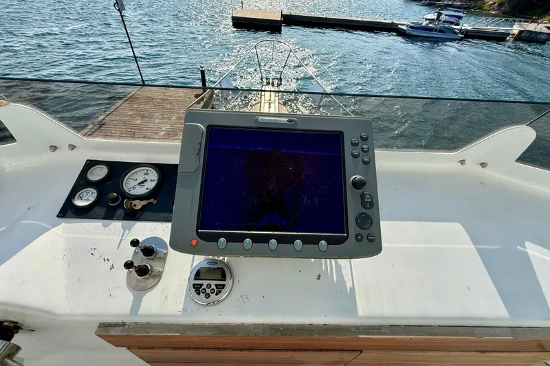  Yacht Photos Pics Helm of 1994 Custom 60 Trawler with navigation equipment and gauges, docked by the water.