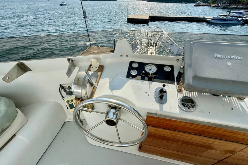  Yacht Photos Pics Helm of 1994 Custom 60 Trawler with steering wheel and navigation equipment.