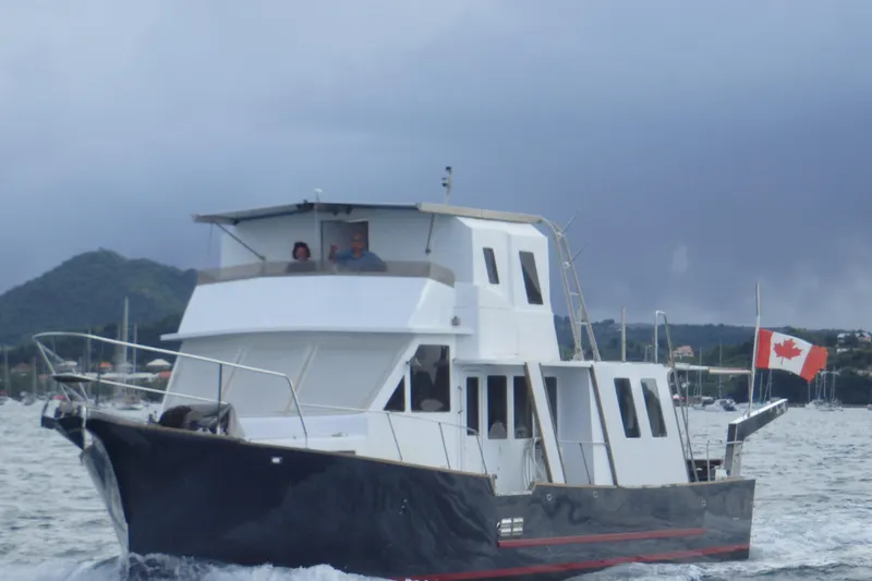  Yacht Photos Pics Custom 60 Trawler 1994 cruising with Canadian flag in scenic waters.