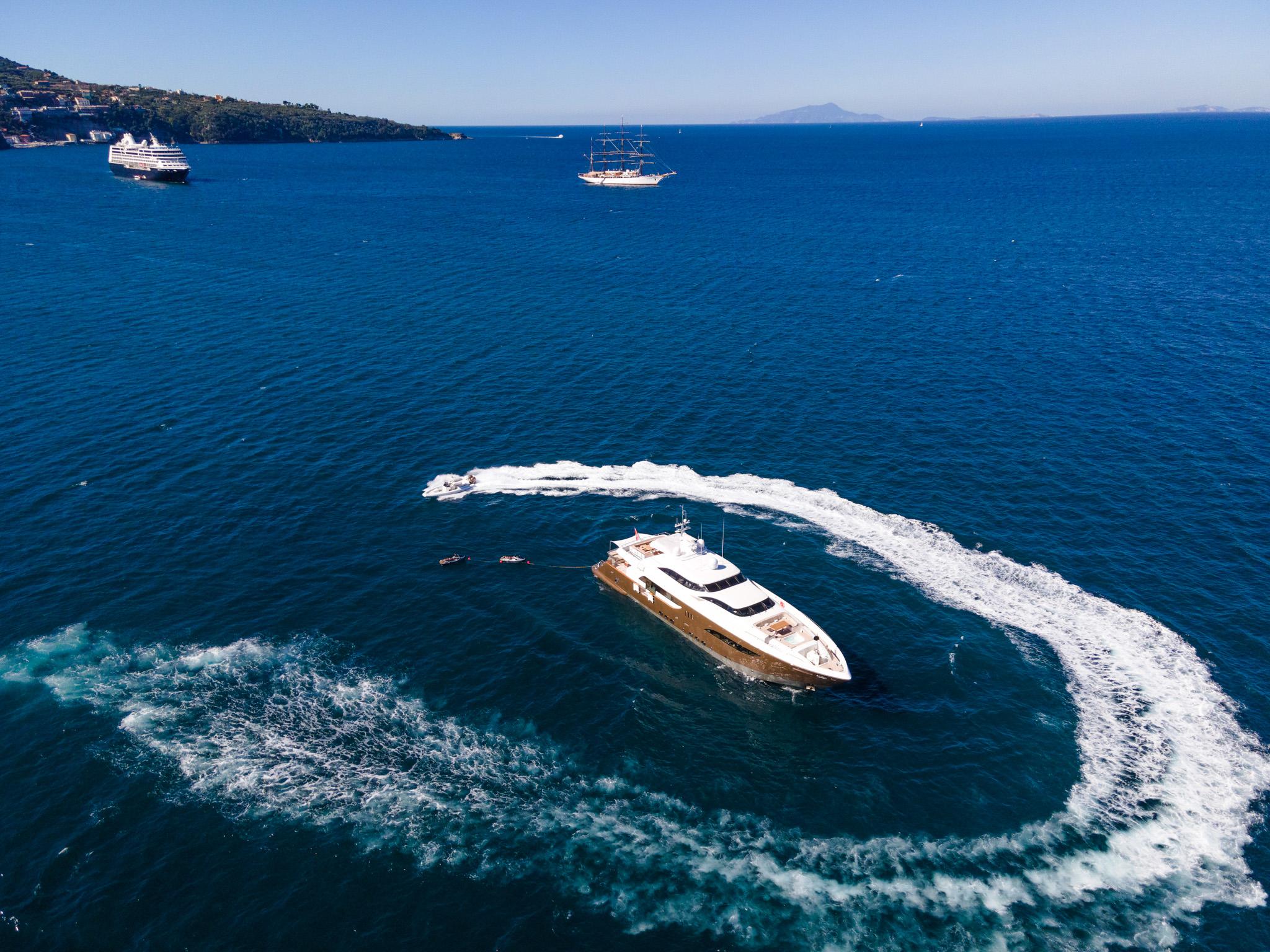 Aerial view of a luxury yacht making a circular wake in the ocean, 2008.