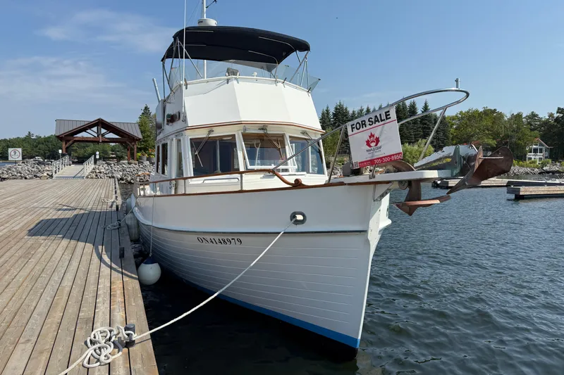  Yacht Photos Pics 1990 Grand Banks 42 Classic yacht docked, for sale sign displayed, calm waters, clear sky.