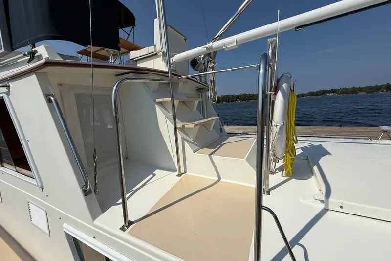  Yacht Photos Pics 1990 Grand Banks 42 Classic yacht deck with stairs and railing, overlooking calm waters.