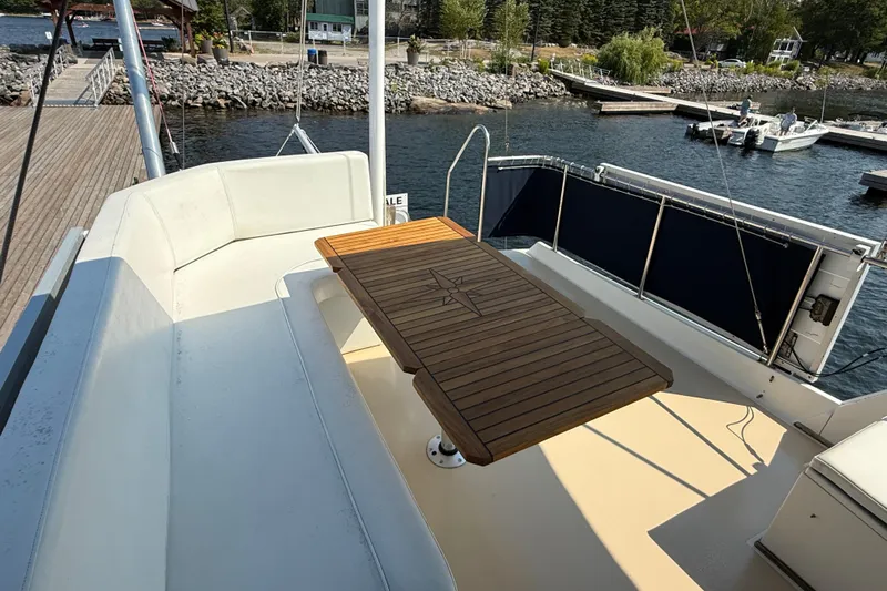  Yacht Photos Pics 1990 Grand Banks 42 Classic yacht deck with seating and wooden table by the water.