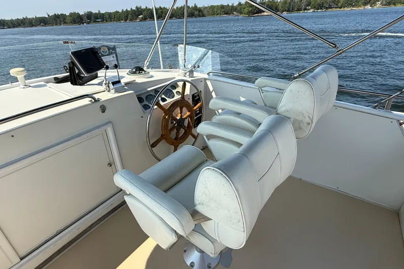  Yacht Photos Pics Helm of 1990 Grand Banks 42 Classic yacht with white seats and wooden steering wheel.