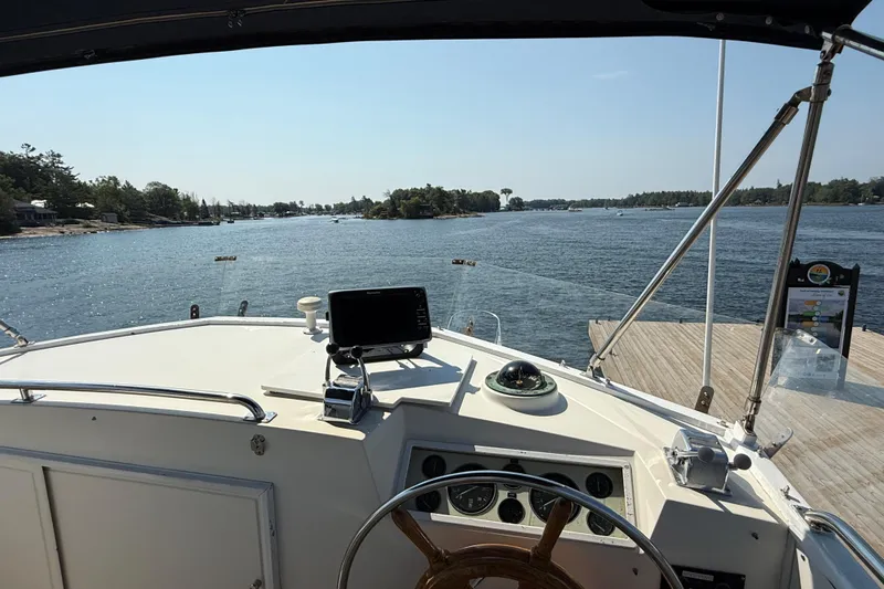  Yacht Photos Pics Cockpit view from 1990 Grand Banks 42 Classic yacht, overlooking serene waters and dock.