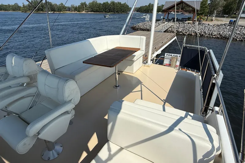  Yacht Photos Pics Flybridge of 1990 Grand Banks 42 Classic yacht with seating and table, docked by water.