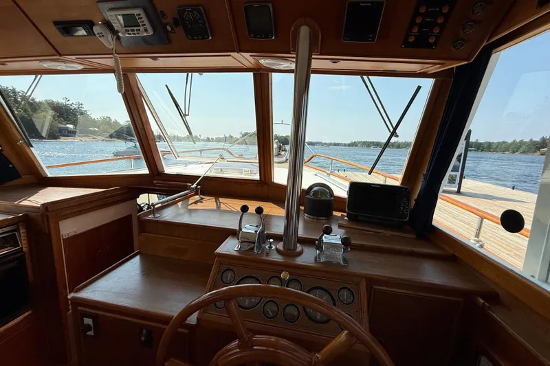  Yacht Photos Pics Interior view of 1990 Grand Banks 42 Classic yacht helm with scenic waterway.