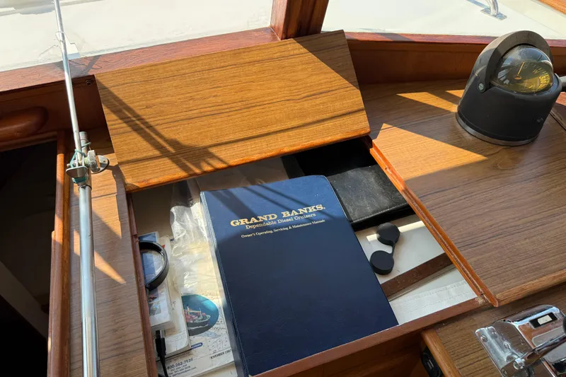  Yacht Photos Pics 1990 Grand Banks 42 Classic interior with manual and compass on wooden dashboard.