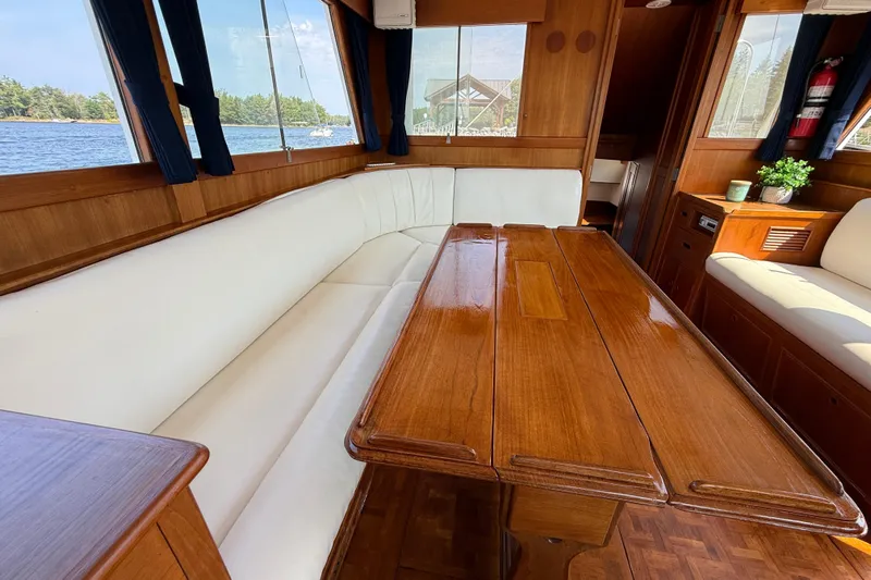  Yacht Photos Pics Interior of 1990 Grand Banks 42 Classic yacht with wooden table and white seating.