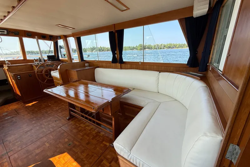  Yacht Photos Pics Interior of 1990 Grand Banks 42 Classic yacht with wooden table and white seating.