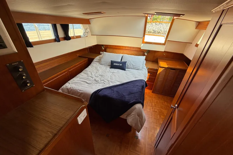  Yacht Photos Pics Cozy bedroom in 1990 Grand Banks 42 Classic yacht with wood accents and natural light.