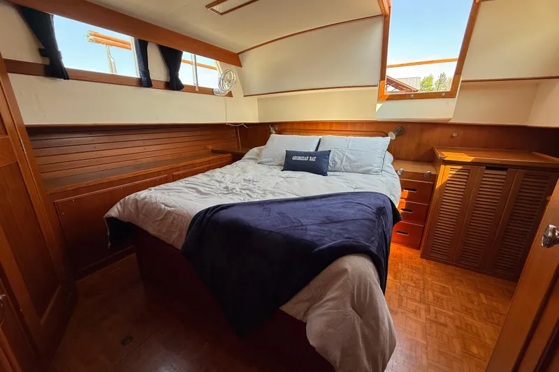  Yacht Photos Pics Cozy bedroom in 1990 Grand Banks 42 Classic yacht with wood paneling and skylight.