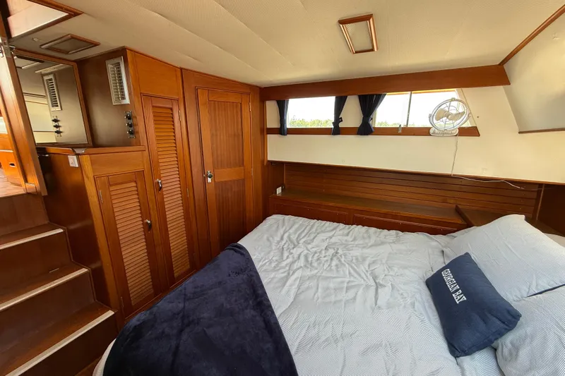  Yacht Photos Pics Cozy bedroom interior of 1990 Grand Banks 42 Classic yacht with wooden cabinetry and bed.
