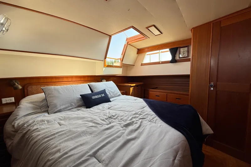  Yacht Photos Pics Cozy bedroom interior of 1990 Grand Banks 42 Classic yacht with wooden accents and natural light.