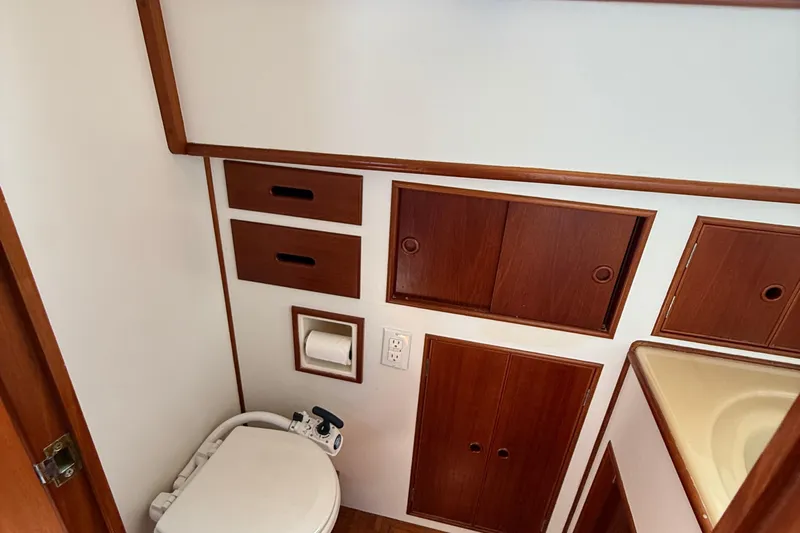 Yacht Photos Pics 1990 Grand Banks 42 Classic yacht bathroom with wooden cabinets and toilet.