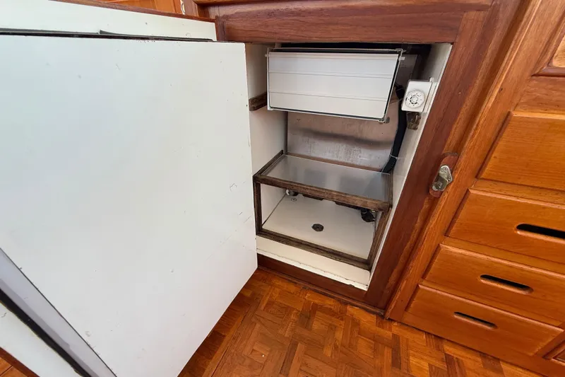  Yacht Photos Pics Open refrigerator in 1990 Grand Banks 42 Classic yacht interior, showcasing wooden cabinetry.