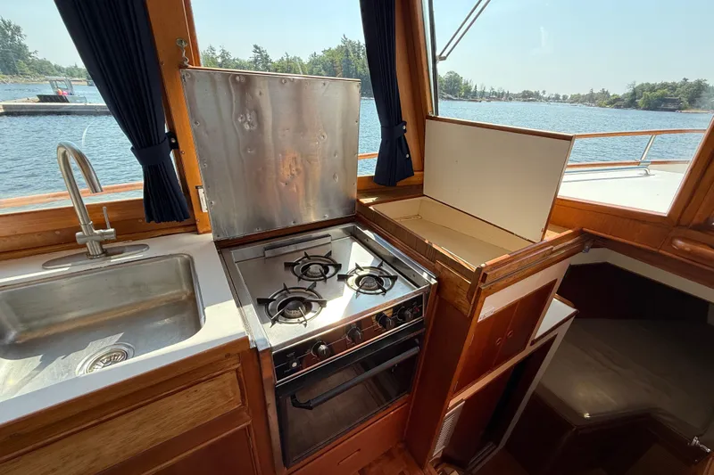  Yacht Photos Pics Galley kitchen in 1990 Grand Banks 42 Classic yacht with stove and sink, overlooking water.