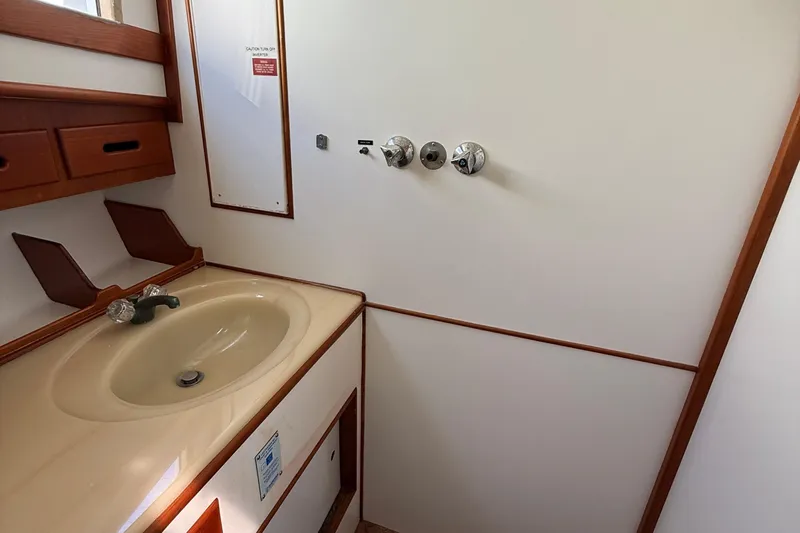  Yacht Photos Pics Bathroom interior of 1990 Grand Banks 42 Classic yacht with sink and wooden accents.